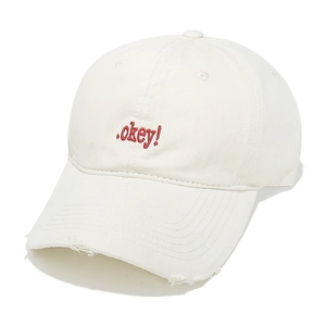 Detailed macro of red okey embroidery and distressed brim on white cotton baseball cap