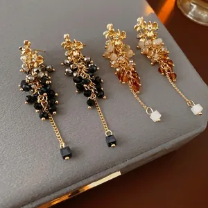 Elegant floral tassel drop earrings with sparkling crystals and beaded layers on velvet