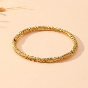 Close-up of golden beaded and textured pillar link bracelet made of stainless steel