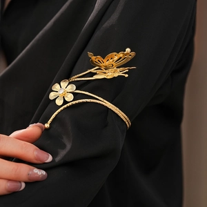 Detailed view of golden butterfly and flower armlet with sparkling rhinestone on arm