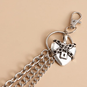 Detail view of silver heart pendant with mini padlock and tiered chain tassels