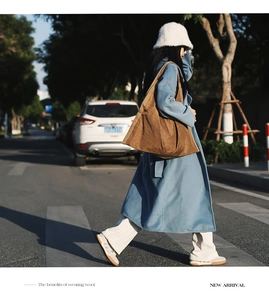 Outdoor street style shot of a trendy brown oversized tote bag with casual autumn outfit