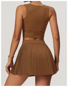 Rear view of caramel brown high-stretch cropped top and pleated mini athletic skirt set