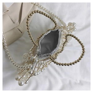 Close-up of pearl bead bucket bag featuring hollow birdcage design and golden handle