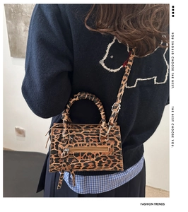 Borsa leopardata alla moda con nappe indossata da una modella per mostrare le dimensioni