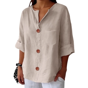 Dettaglio di camicia estiva in lino con scollo a V, bottoni marroni e maniche rimboccate