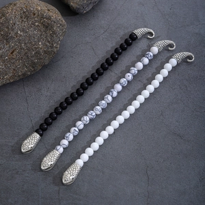 Dettaglio dei bracciali con perline da 8mm e chiusura a forma di testa di serpente