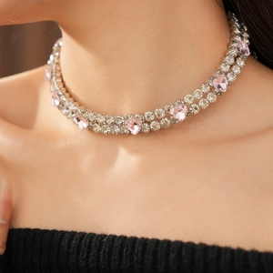 Détail macro du collier choker double rang avec cristaux de cœur roses sur le cou