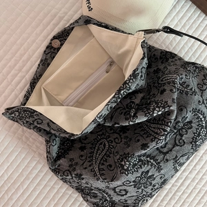 Close-up of paisley canvas tote bag featuring magnetic closure and inner zipper pocket
