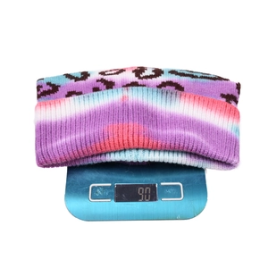 Leopard print tie-dye knitted beanie with blue purple gradient on weighing scale