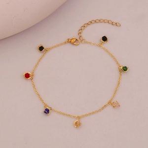 Detailed shot of golden anklet featuring colorful crystal charms and lobster clasp