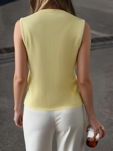Back view of a yellow knitted Y2K high neck sleeveless vest for women in natural light