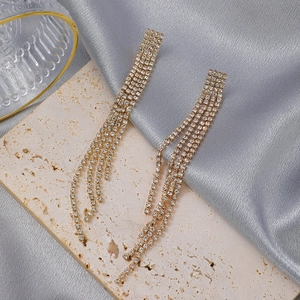 Detail of luxury long tassel earrings with sparkling rhinestones on golden metal base