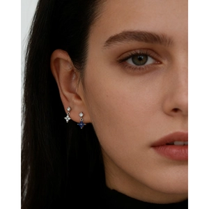Close-up of s925 silver four-leaf clover stud earrings with blue and white zircon on ear