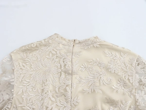 Dettaglio ricamo floreale 3D su abito beige con cerniera lampo invisibile sul retro
