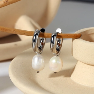 Detailed view of minimalist stainless steel hoop earrings with natural freshwater pearl pendants