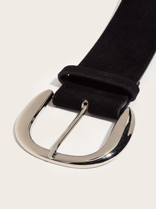 Close-up of black suede belt with large polished silver metal buckle and soft texture
