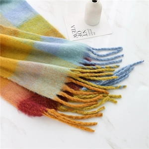 Detailed macro view of colorful gradient rainbow plaid scarf with long soft tassels