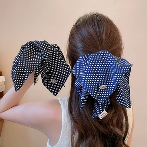 Detail of polka dot scrunchies with handmade labels and metallic bow accents