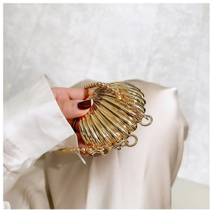 Detailed view of mini golden shell evening bag with beaded chain and metallic texture