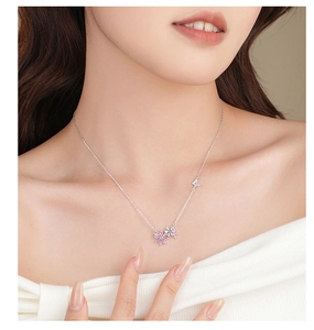 Close-up of S925 silver flower and butterfly pendant necklace on a female model