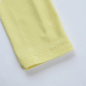 Détail d'une robe en maille jaune montrant des coutures à double aiguille et un tissu doux