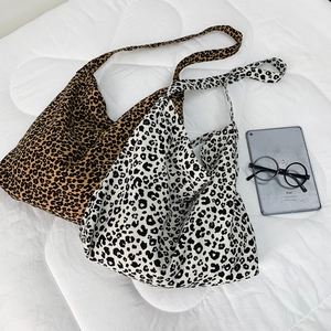 Top view of two large leopard print canvas tote bags in brown and black-and-white tones