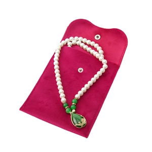 Pearl necklace with green water-drop pendant and a magenta velvet jewelry pouch