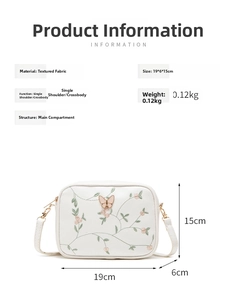 Detailed size specifications of white camera bag with floral embroidery and butterfly clasp