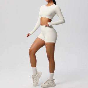 Detail of off-white long sleeve crop top and high waist yoga shorts set on model