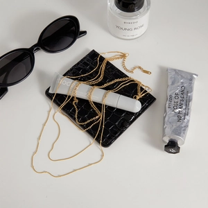 Détail du collier à étages en acier inoxydable doré 18K avec perles sur fond chic
