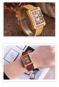 Close-up of vintage rectangular wooden watches with Roman numeral dial and leather strap