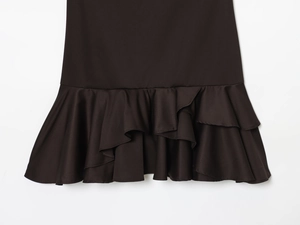 Detailed view of the layered ruffle hem and smooth black fabric on this short dress