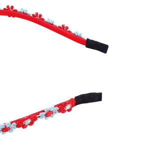 Detail of red floral woven headband with intricate blue flower embroidery details