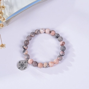 Detailed view of natural agate stone bead bracelet with a silver compass charm pendant
