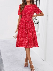 Détail d'une robe rouge à pois avec manches courtes, col rond et ceinture à nouer