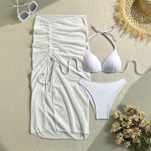 Close-up of white 3-piece bikini set with sheer mesh sarong and beach accessories