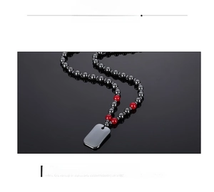 Detail of hematite bead necklace featuring four red accents and a black polished pendant