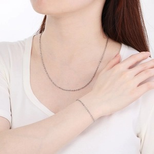 Detail of silver stainless steel embossed link chain necklace and bracelet on model