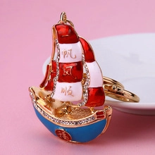 Macro detail of golden sailboat keychain with rhinestones and lucky Chinese characters
