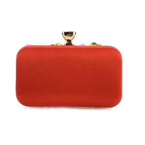 Detail of red satin evening clutch with sequin floral embellishments and gold clasp