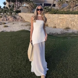 Elegant white strapless maxi dress with mesh layered skirt standing in nature