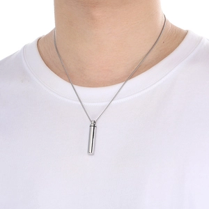 Polished silver cylinder perfume bottle pendant on model with minimalist steel chain