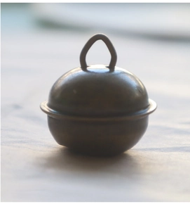 Gros plan détaillé d'une cloche en bronze antique de 22mm avec boucle de suspension pour artisanat