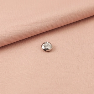 Gedetailleerd beeld van zilveren schelpvormige metalen kraal voor DIY-sieraden