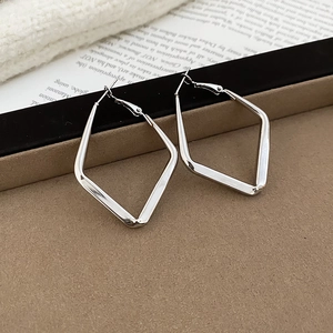 Detailed view of silver rhombic geometric hoop earrings with polished metallic finish