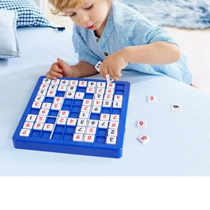 Toddler playing with a blue Sudoku board game for logical thinking development