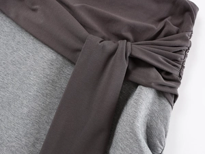Detail of color-block knit skirt featuring lace-up waist and contrast gray fabric texture