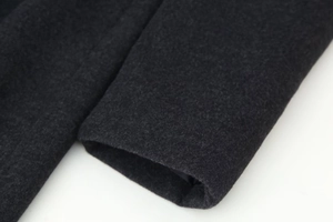 Detailed macro shot of dark grey wool fabric texture on long coat sleeve cuff