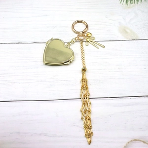 Close-up of golden mesh drawstring pouch keychain with bow and heart pendants